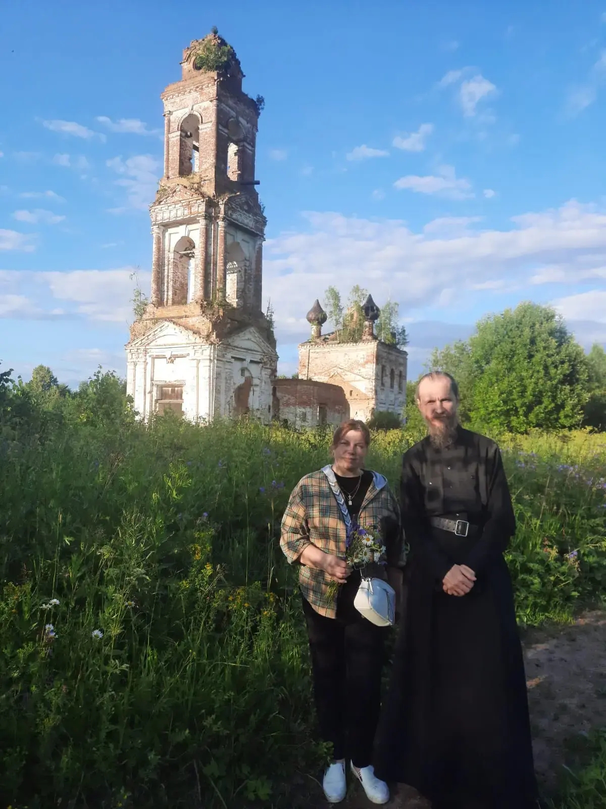 игумен Спасо-Каменного монастыря в Вологодской области о. Дионисий (Воздвиженский) и экскурсовод Вера Федотова у стен церкви Николы на Быстрых